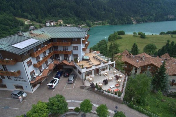 Hotel s výhľadom na jazero a lesy.  