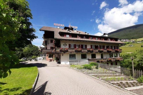 Hotel v alpskej krajine s modrou oblohou.
