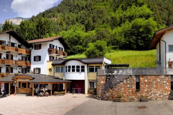Horský hotel obklopený zelenými kopcami.