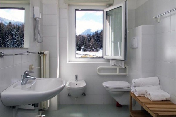 Kúpeľňa s umývadlom, WC a bidetom, výhľad z okna na zasnežené hory.