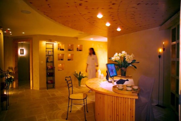 Interiér wellness centra s recepciou a kvetmi na pulte.