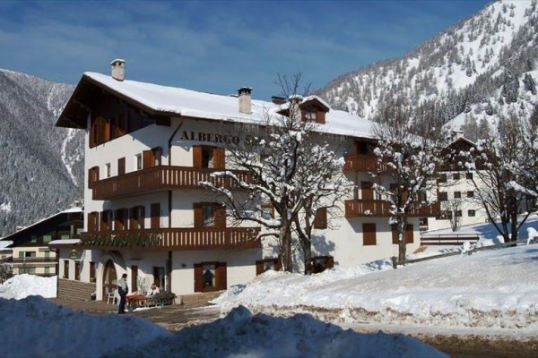 Horský hotel so zasneženou strechou v zimnej krajine.