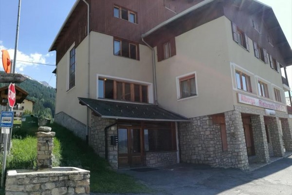 Trojposchodová budova s kamennými detailmi a nápisom 