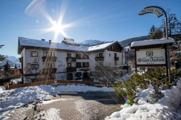 Horský hotel pokrytý snehom s nápisom 