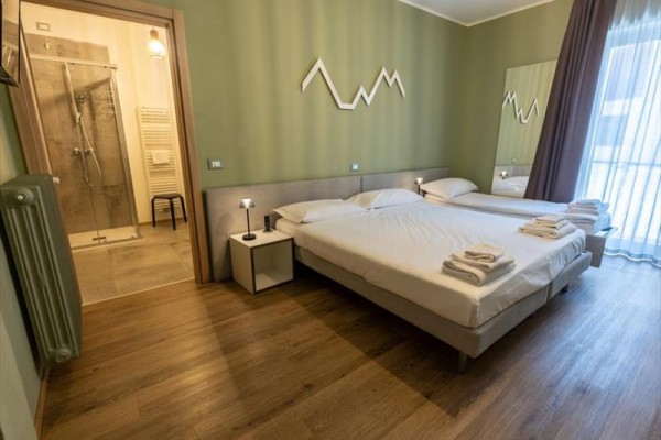 Moderná hotelová izba s dvoma lôžkami a kúpeľňou.