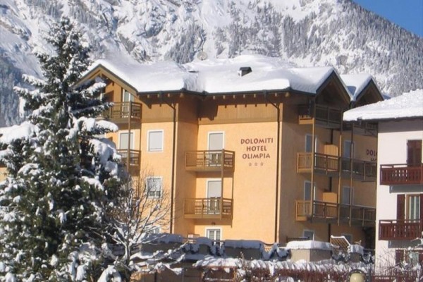 Hotel Dolomiti Olimpia v zasneženej horskej krajine.