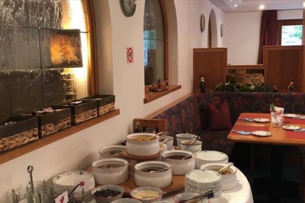 Bufetový stôl s hrncami a miskami v reštaurácii s rustikálnym interiérom.